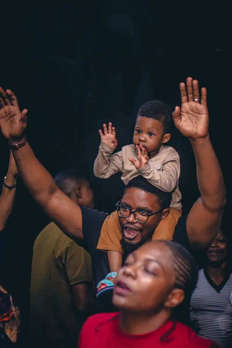 A father worshipping with his son on his shoulders